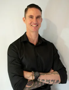 Josh Roche standing with arms folded